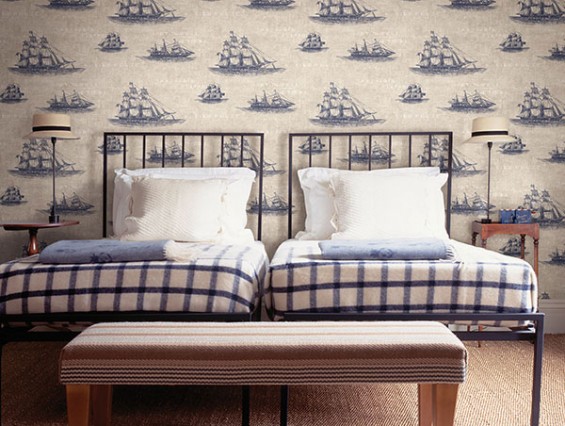 Decoración de dormitorio, papel pintado con detalles náuticos, dibujos de barcos azules sobre fondo blanco colcha a cuadros blanco y azul